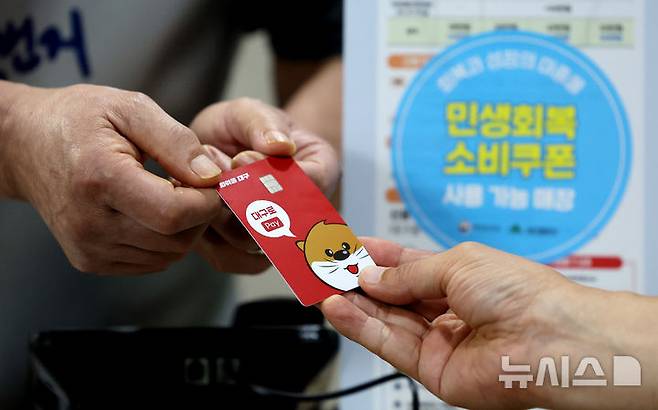 [대구=뉴시스] 이무열 기자 = 민생회복 소비쿠폰 신청 이틀째인 지난 22일 대구 중구 한 음식점에서 식사를 마친 시민이 소비쿠폰이 입금된 선불카드로 결제하고 있다. 2025.07.22. lmy@newsis.com