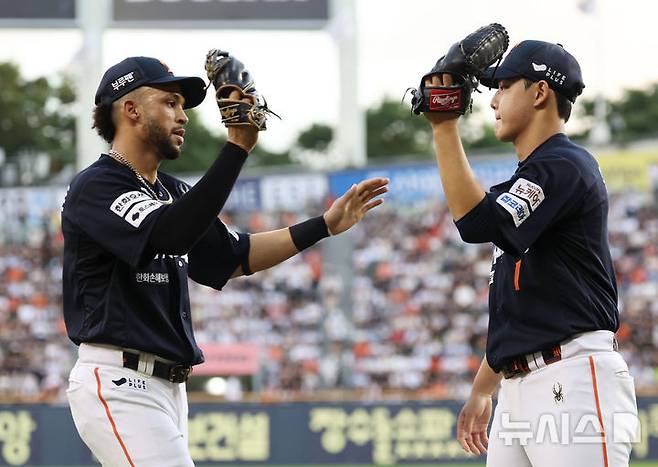 [서울=뉴시스] 홍효식 기자 = 22일 서울 송파구 잠실야구장에서 열린 2025 KBO리그 한화 이글스와 두산 베어스의 경기, 3회말 수비를 마친 한화 선발투수 문동주가 호수비를 보여준 리베라토와 하이파이브를 하고 있다. 2025.07.22. yesphoto@newsis.com