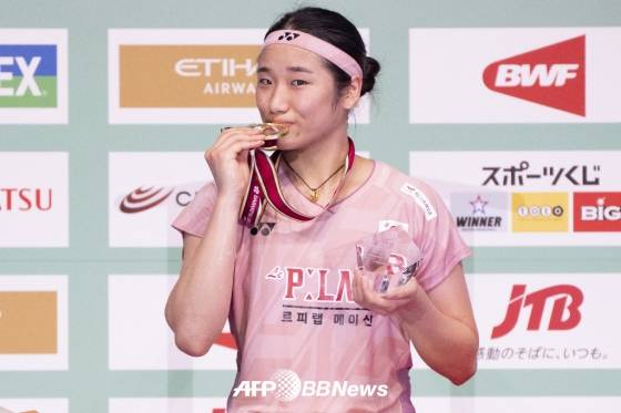 안세영이 20일 일본 도쿄에서 열린 세계배드민턴연맹(BWF) 월드투어 슈퍼 750 일본오픈 여자단식 결승에서 왕즈이를 2-0(21-12, 21-10)으로 꺾고 우승을 차지한 뒤 시상식에서 금메달을 입에 맞추는 세리머니를 하고 있다. /AFPBBNews=뉴스1