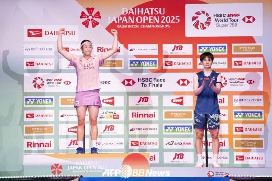 안세영(왼쪽)이 20일 일본 도쿄에서 열린 세계배드민턴연맹(BWF) 월드투어 슈퍼 750 일본오픈 여자단식 결승에서 왕즈이(오른쪽)를 2-0(21-12, 21-10)으로 꺾고 우승을 확정한 뒤 시상대에 올라 기뻐하고 있다. /AFPBBNews=뉴스1