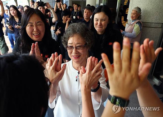 61년 만에 인정받은 정당방위 (부산=연합뉴스) 손형주 기자 = 61년 전 자신을 성폭행하려던 남성의 혀를 깨물어 중상해 혐의 유죄 판결을 받았던 최말자(78)씨가 23일 부산지법에서 열린 재심 첫 공판을 마치고 법정을 나서며 변호인과 여성단체의 박수를 받고 있다.  2025.7.23 handbrother@yna.co.kr