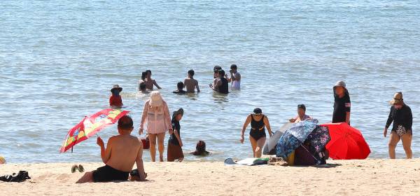 폭염이 이어진 24일 인천 중구 을왕리해수욕장을 찾은 피서객들이 양산을 받쳐 들고 더위를 식히고 있다.연합