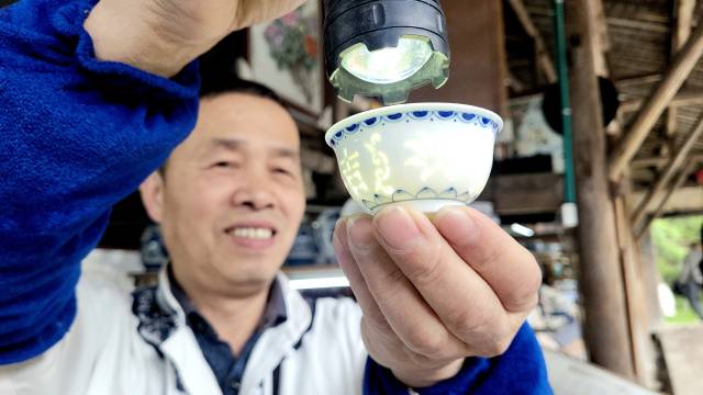 징더전 고요(古) 민속 박람구에서 한 장인이 도자기 특정 부분의 무늬를 빛이 비치게끔 얇게 구워낸 기법을 선보이고 있다.