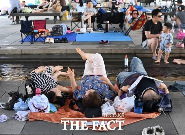 …[더팩트ㅣ이새롬 기자] 서울 낮 최고기온이 36도까지 오른 12일 오후 서울 여의도 한강공원 물빛광장을 찾은 시민들이 물가에 모여 더위를 식히고 있다.