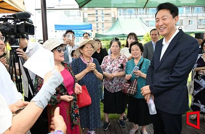 오세훈 서울시장이 24일(목) 오후 신당9구역 재개발 현장에서 지역 주민들에게 주택공급 촉진 방안을 설명한 후 이야기를 나누고 있다. 서울시 제공