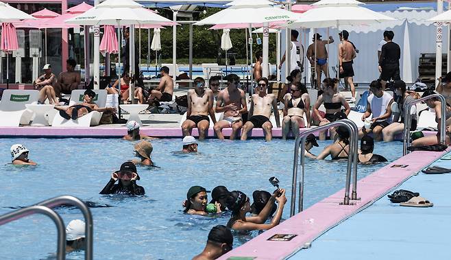 People enjoy the water at Jamwon swimming pool in Hangang Park on July 10. The pool draws over 1,000 visitors even on weekdays, most of them in their 20s and 30s. [KIM KYOUNG-ROK]