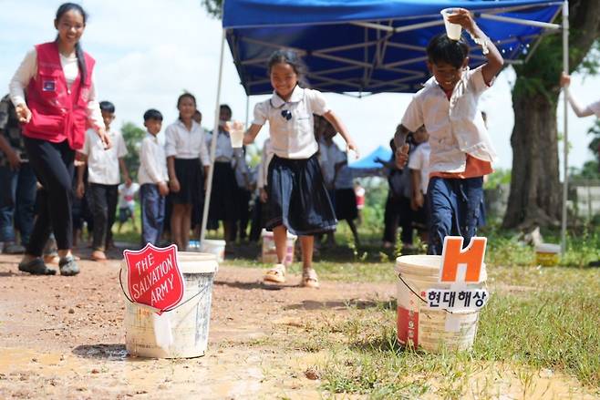 23일 캄보디아 캄폿 ‘쓰라에 찌어 트마이’ 초등학교에서 열린 운동회에서 한 학생이 물컵을 이고 달리기 경기에 참여하고 있다.