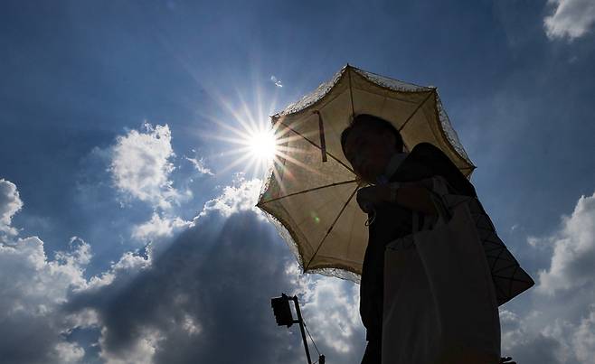 대구에 폭염경보가 이어진 23일 동대구역 광장에서 한 시민이 양산을 쓰고 이동하고 있다. [사진 출처 = 연합뉴스]