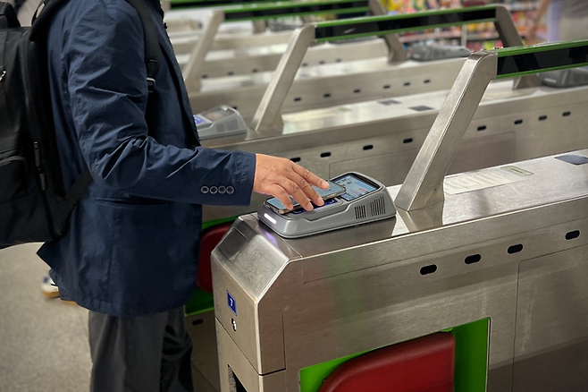 24일 아침 출근시간 여의도역에서 한 직장인이 ‘애플페이 티머니’로 교통요금을 지불하고 있는 모습. [사진 = 김민주 기자]