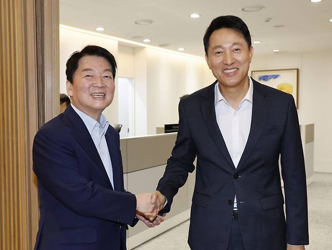 국민의힘 당권 주자인 안철수 의원(왼쪽)이 24일 오세훈 서울시장과의 오찬 회동을 위해 서울시청을 방문해 오 시장과 인사하고 있다. [공동취재]