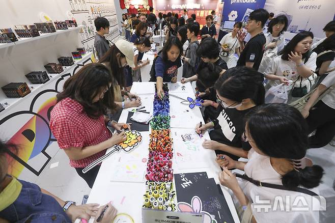 [서울=뉴시스] 김근수 기자 = 서울일러스트레이션페어V.19 2025 개막 첫 날인 24일 서울 강남구 코엑스에서 관람객들이 컬러펜으로 그림을 그리고 있다. 2024.07.24. ks@newsis.com