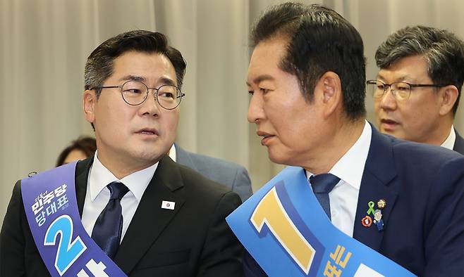 더불어민주당 정청래·박찬대(왼쪽) 당대표 후보가 지난 20일 서울 여의도 당사에서 열린 8·2 전당대회 순회 경선 영남권 합동연설회에서 대화하고 있다. 연합뉴스