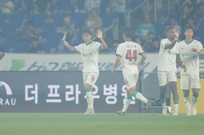 대전하나시티즌 이명재(왼쪽)가 23일 울산 문수월드컵경기장에서 열린 2025 K리그1 23라운드 울산 HD와의 원정 경기에서 골을 넣고 친정팀에 대한 예우로 세리머니를 자제하고 있다. 전반 42분 울산 에릭의 선제골이 터지고 2분 만에 이명재가 균형을 맞추면서 홈팀 울산의 득점을 축하하는 폭죽의 연기가 여전히 그라운드를 채우고 있다. K리그 제공