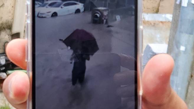 ​광주 북구 신안교 인근에 거주하는 한 주민이 지난 17일 오후 5시께 발생한 실종 사고 인물로 추정된 80대 남성 김아무개씨의 행적이 담긴 영상을 취재진에게 보여주고 있다. ⓒ시사저널 정성환​