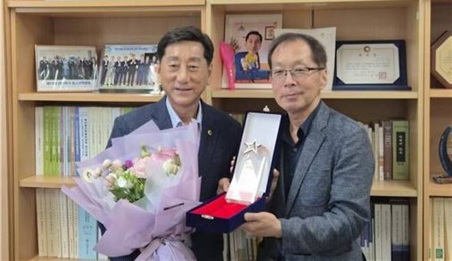 ▲ 지난 23일 인천시의회를 찾은 김용기(오른쪽) 인천시 장애인직업재활시설협회장이 이봉락(왼쪽) 인천시의회 의원에게 감사패와 꽃다발을 전달하고 있다. /사진제공=인천시 장애인직업재활시설협회