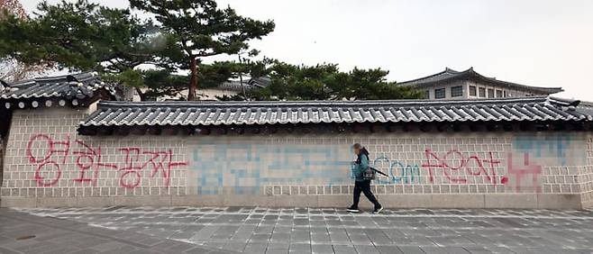 경복궁 서쪽 담벼락에 붉은색과 푸른색 스프레이로 적은 ‘영화공짜’라는 낙서./연합뉴스