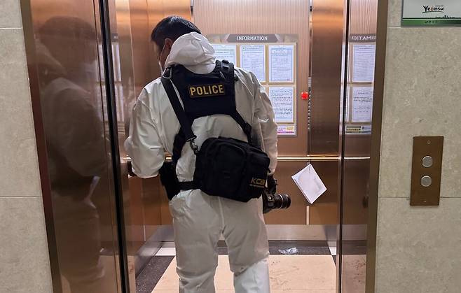 21일 총기 사고가 발생한 인천 연수구 한 아파트 단지에 경찰 수사관이 엘리베이터를 타고 들어가고 있다. / 뉴스1