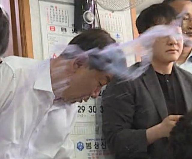 우범기 전주시장이 25일 오전 11시 50분쯤 완주군 봉동의 한 식당에서 통합 반대 군민으로부터 '물벼락'을 맞고 있다. 연합뉴스