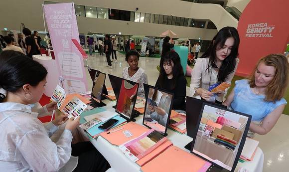 지난달 19일 서울 동대문디자인플라자(DDP)에서 열린 '2025 코리아뷰티페스티벌'을 찾은 외국인들이 각종 체험을 하고 있다. [사진=연합뉴스]