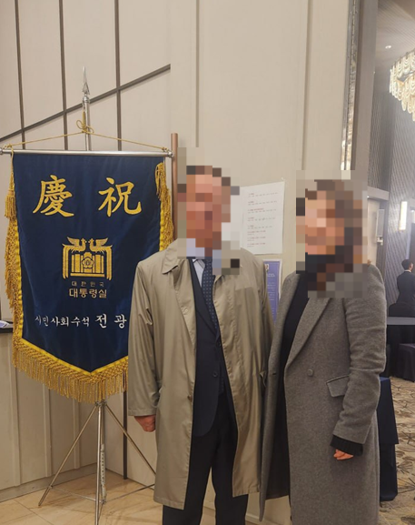 손효숙 리박스쿨 대표가 운영하는 방과후학교 위탁기업 ‘글로리사회적협동조합’의 감사이자 KHHC의 이사인 A씨(오른쪽)가 대통령실 축기를 배경으로 서 있다. KHHC 홈페이지 갈무리