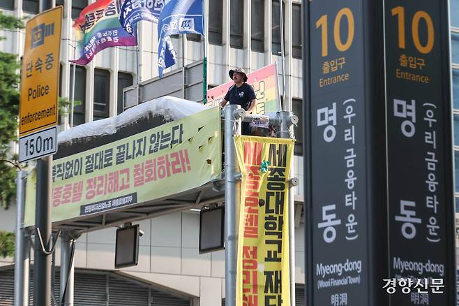 정리해고 철회 등을 촉구하며 163일째 고공농성 중인 고진수 민주노총 세종호텔 지부장이 25일 서울 세종호텔 앞 고공 농성장에서 김영훈 고용노동부 장관과 전화 통화를 하기 위해 기다리고 있다.  성동훈 기자