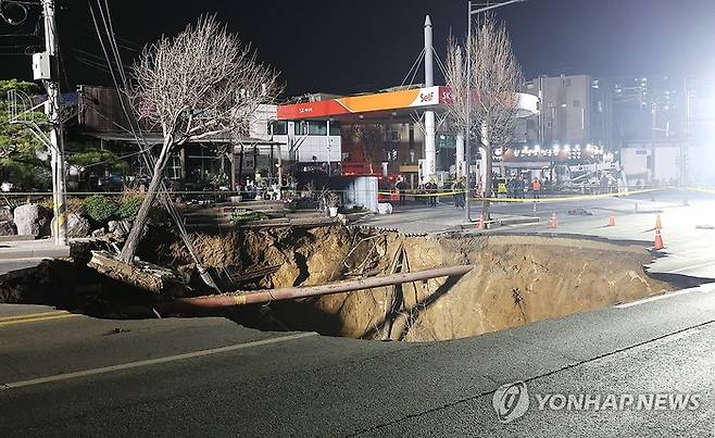 지난 3월 24일 싱크홀(땅 꺼짐) 사고가 발생한 서울 강동구 대명초등학교 인근 사거리에서 소방대원들이 현장 수색 및 구조작업을 준비하고 있다.  연합뉴스
