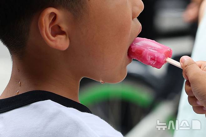 [서울=뉴시스] 권창회 기자 = 서울지역에 이틀째 폭염주의보가 지속중인 1일 서울 종로구 광화문광장 인근에서 어린이가 땀을 흘리며 아이스크림을 먹고 있다. 2025.07.01. kch0523@newsis.com