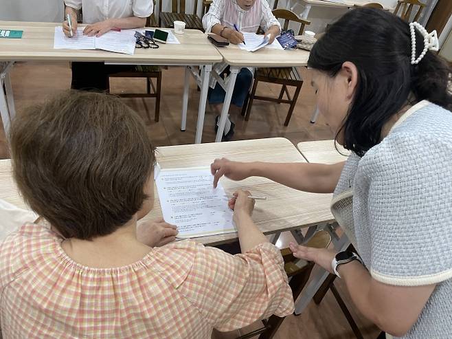 지난 6월 경기 부천 범안종합사회복지관에서 전문 상담사가 노후 준비 설문지 작성을 안내하고 있다.  부천 신중년 노후준비지원센터 제공