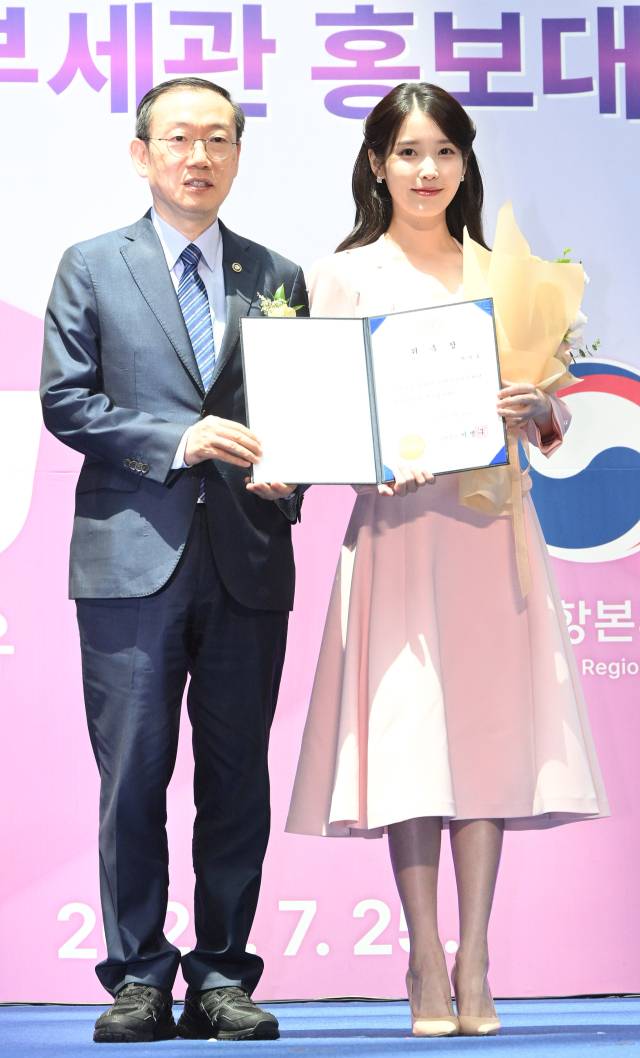 아이유(IU·본명 이지은)가 25일 인천국제공항 제1터미널에서 열린 인천공항본부세관 홍보대사 위촉식에서 이명구 관세청장에게 위촉장을 받은 뒤 기념 촬영을 하고 있다. 영종도=오승현 기자 2025.07.25