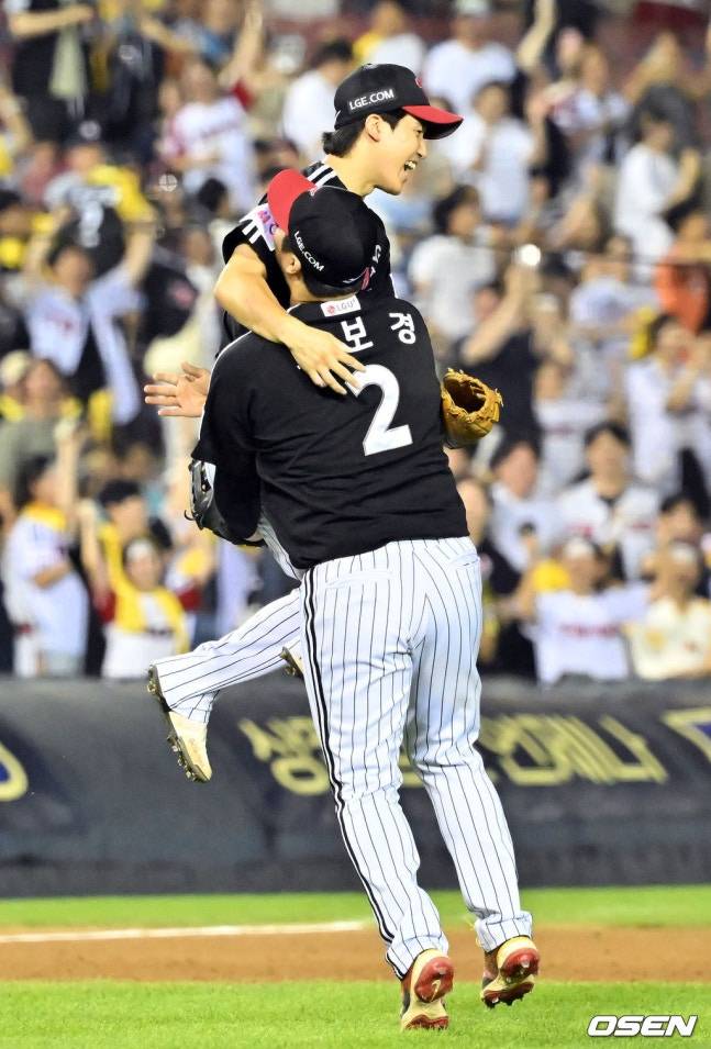 LG 문보경(오른쪽)이 25일 잠실 두산전 9회말 2사 1, 3루에서 이유찬의 뜬공 타구를 담장을 타고 낚아챈 구본혁을 끌어안고 있다. /사진=OSEN 제공