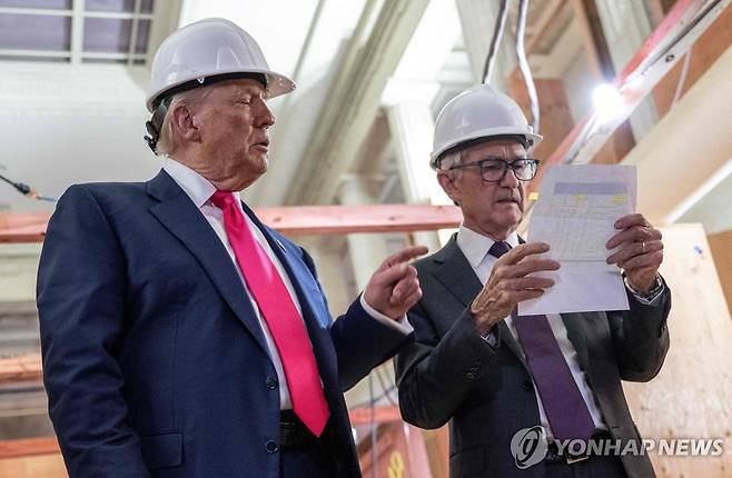 24일(현지시간) 미국 워싱턴DC 연준 본부를 방문한 도널드 트럼프 미국 대통령(왼쪽) 제롬 파월 연준 의장과 대화하며 비용 내역서를 가리키고 있다.[AFP=연합뉴스. 재판매 및 DB 금지]