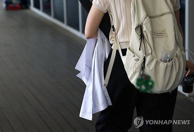 의대생 복귀 상황은? (서울=연합뉴스) 김성민 기자 = 정부와 교육계가 '의대 교육 정상화 방안'을 논의하는 가운데 의대 총장들이 의대 본과 4학년이 추가로 의사국가시험(국시)를 치를 수 있도록 정부에 건의하기로 했다.
    23일 서울 시내 한 의과대학에서 한 학생이 가운을 들고 걸어가고 있다. 2025.7.23 ksm7976@yna.co.kr