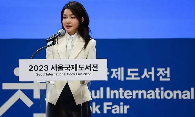 김건희 여사가 2023년 6월14일 ‘2023 서울국제도서전’에서 축사하고 있다. 도서전 주최 쪽에서 1천만원을 더 들여 급히 변경한 도안으로 개막식 무대를 꾸민 뒤다. 대통령실 제공