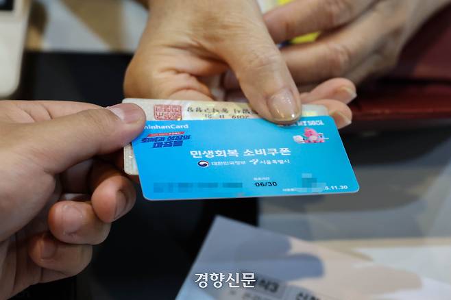 민생회복 소비쿠폰 1차 신청이 시작된 지난 21일 서울 동작구 대방동주민센터에서 주민이 선불카드를 발급받고 있다. 성동훈 기자