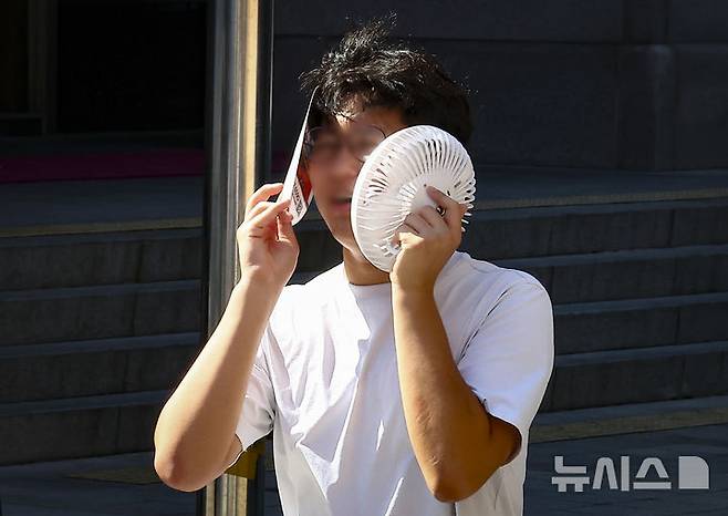 [서울=뉴시스] 김근수 기자 = 연일 이어지는 무더위 속에 26일 서울 중구 남산한옥마을을 찾은 한 관람객이 부채로 햇볕을 가리며 걸어가고 있다. 2024.07.26. ks@newsis.com