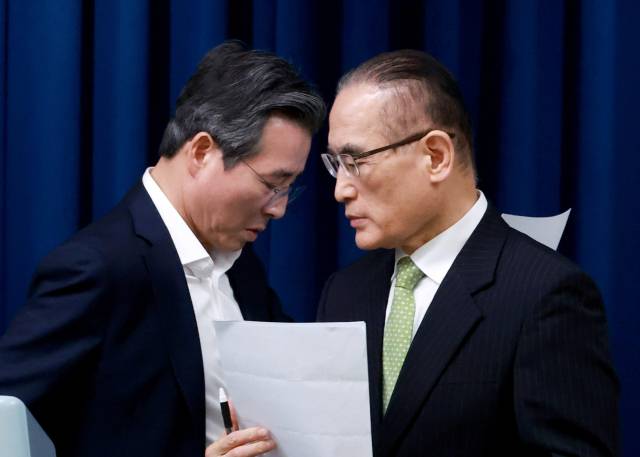 김용범(왼쪽)대통령실 정책실장과 위성락 국가안보실장이 25일 서울 용산 대통령실 청사에서 이날 강훈식 대통령비서실장 주재로 열린 통상대책회의 관련 브리핑에 대한 취재진의 질문에 답하기 위해 마이크 앞 자리를 바꾸고 있다. 연합뉴스