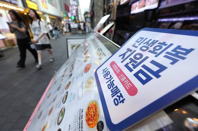 '민생회복 소비쿠폰' 1차 신청 닷새 간 전체 대상자의 72.0%인 3642만5598명이 신청했다고 행정안전부가 26일 밝혔다. 사진은 지난 24일 서울 시내 한 음식점 메뉴판에 민생회복 지원금 안내문이 붙어 있는 모습 ⓒ연합뉴스