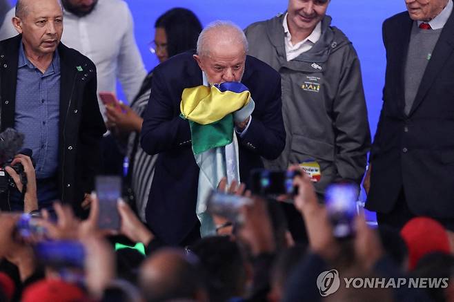 25일(현지시간) 행사에서 국기에 키스하는 브라질 룰라 대통령 [오사스쿠 로이터=연합뉴스. 재판매 및 DB 금지]