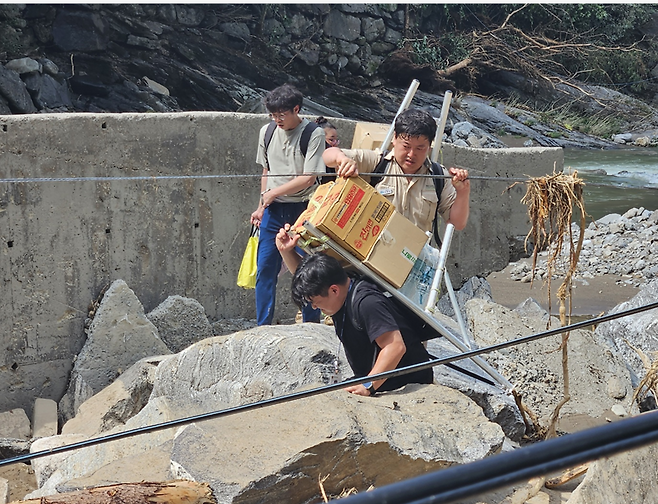 도립공원 직원들이 지게로 생필품을 나르고 있다.