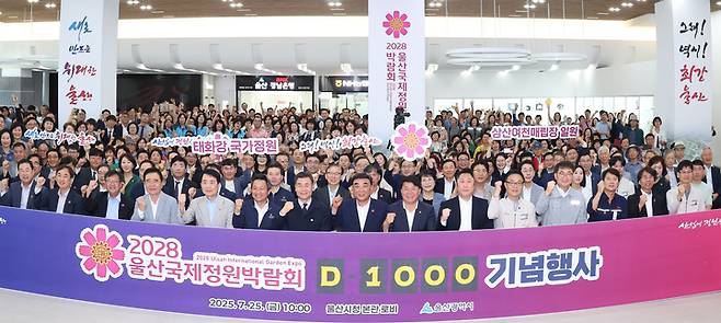 '2028 울산국제정원박람회 D-1000 기념행사'가 지난 25일 울산시청 본관 로비에서 개최된 가운데 김두겸 울산시장, 이성룡 울산시의회 의장, 김영길 울산 중구청장, 김철 울산공업축제추진위원장, 김철욱 울산시체육회장, 정원 관계자 및 시민 등이 성공적인 박람회 개최를 기원하며 기념촬영을 하고 있다. 이수화 기자