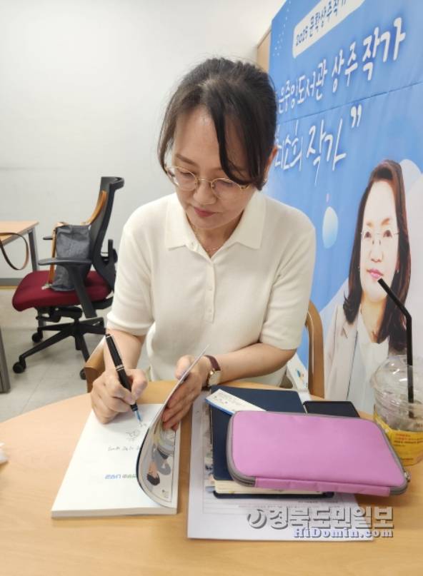 최소희 동화작가가 기자에게 줄 저서에 서명을 하고 있다. 사진= 황지환 인턴기자