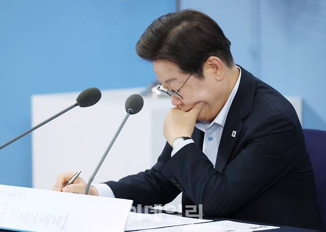 이재명 대통령이 25일 부산 부경대에서 열린 타운홀미팅 ‘부산의 마음을 듣다’ 지역 주민 간담회에서 자료를 살펴보고 있다.(사진=뉴시스)