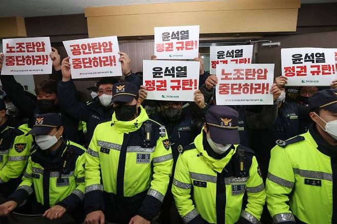 2023년 민주노총 건설노조 조합원들이 압수수색이 진행되고 있는 서울 영등포구 민주노총 건설노조 서울경기북부지부 사무실 앞에서 손팻말을 들고 있다. 경찰은 당시 건설현장 불법행위로 양대노총 건설노조를 압수수색했다. 연합뉴스