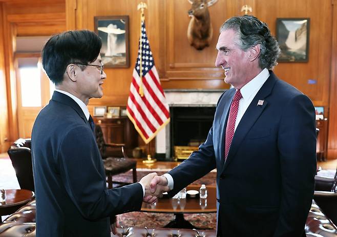 김정관 산업부 장관(왼쪽)이 24일 워싱턴 DC에서 더그 버검 내무 장관과 만나 악수를 하고 있다. /뉴스1