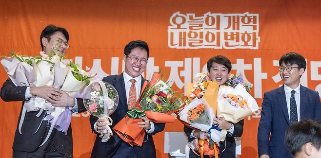 개혁신당 당 대표 선거에 단독 출마한 이준석 의원이 27일 국회의원회관 대회의실에서 열린 개혁신당 제2차 전당대회에서 당 대표로 확정된 뒤 최고위원 선출자들과 꽃을 받고 있다. (왼쪽부터) 김정철, 김성열 최고위원, 이 대표, 주이삭 최고위원/연합뉴스