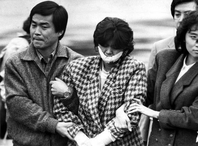 1987년 12월 15일 국가안전기획부(현 국가정보원) 직원들이 김포공항에서 'KAL기 폭파 사건'(같은 해 11월 29일 발생)의 용의자인 북한 공작원 김현희(가운데)를 연행하고 있다. 김현희는 당시 '하치야 마유미'라는 이름으로 활동했다. 한국일보 자료사진