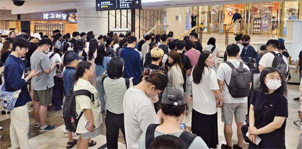 지난 25일 롯데백화점 부산본점 지하 1층 ‘포켓몬 캡슐 스테이션 인 부산’ 팝업스토어 오픈을 기다리는 고객들이 백화점 입구에서 긴 줄을 선 채 기다리고 있다.   롯데백화점 제공