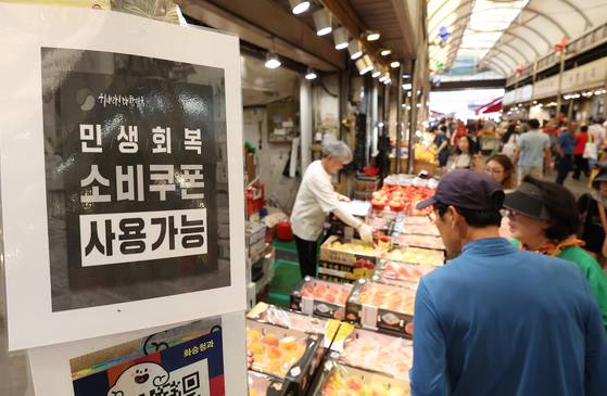 A sign reading “Consumer Coupons Accepted Here” is posted at a shop in Cheongnyangni Traditional Market in eastern Seoul on July 27. [YONHAP]