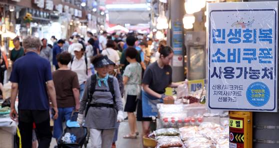 A sign reading “Consumer Coupons Accepted Here” is posted at a shop in Cheongnyangni Traditional Market in eastern Seoul on July 27. [NEWS1]