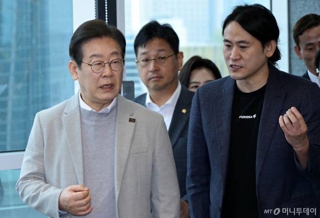 (서울=뉴스1) 국회사진취재단 = 이재명 대통령이 지난 4월 대선 예비후보 시절 서울 강남구 퓨리오사AI에서 백준호 퓨리오사AI 대표와 대화하며 이동하고 있다. 2025.4.14/뉴스1  Copyright (C) 뉴스1. All rights reserved. 무단 전재 및 재배포,  AI학습 이용 금지. /사진=(서울=뉴스1) 국회사진취재단